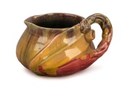 REMUED pottery jug with applied gumnuts, leaf and branch handle, unusual pink, mauve and mustard glaze with green interior, incised "Remued", 7cm high, 13cm wide