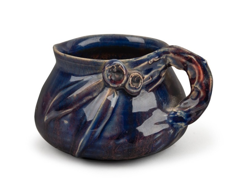 REMUED pottery jug with applied gumnuts, leaves and branch handle, in dark blue glaze with pink highlights, incised "Remued", 7.5cm high, 12.5cm wide