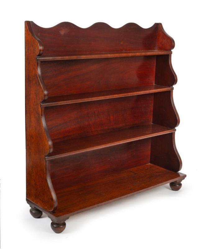 An early Colonial cedar waterfall front bookcase with scalloped backboard, all resting on vase shaped feet, Tasmanian origin, circa 1840, 122cm high, 118cm wide, 35cm deep