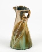 REMUED&nbsp;unusual pottery jug with applied gumnut, leaf and branch handle, glazed in green, cream and blue, incised "Remued, 307M", 15cm high