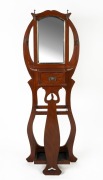 An Australian solid blackwood art nouveau style hallstand with an arch-top bevelled mirror, single drawer and pierced splat, circa 1915, ​​​​​​​187cm high, 66cm wide, 53cm deep
