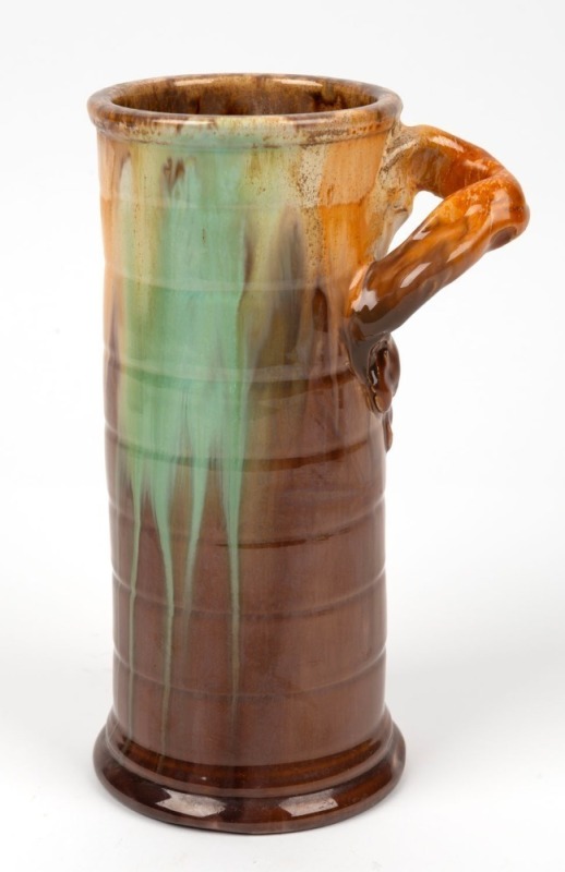 REMUED ribbed cylindrical pottery vase glazed in brown and green with cream highlights, incised "Remued 145/9", 23cm high