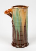 REMUED ribbed cylindrical pottery vase glazed in brown and green with cream highlights, incised "Remued 145/9", 23cm high - 2