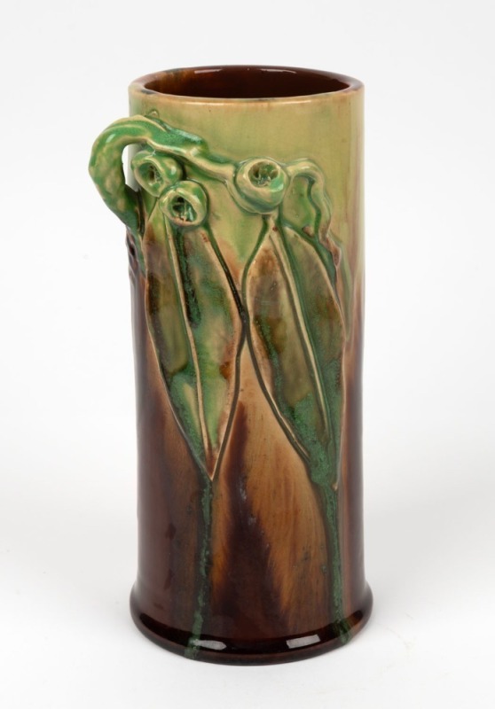 REMUED cylindrical pottery vase with applied gumnuts and leaves, glazed in green and brown, incised "Remued, Hand Made, 145/9M", 23.5cm high