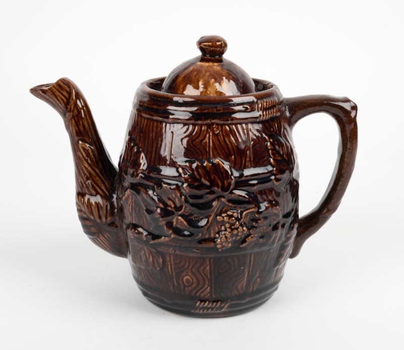 An antique barrel shaped pottery teapot with grape motif and Rockingham glaze, 19th century, impressed mark "Fire Proof", 19cm high