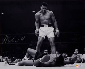 MUHAMMAD ALI, signed b/w photograph of Ali standing over Sonny Liston, size 51x41cm. With 'Online Authentics' No.OA-8090298.