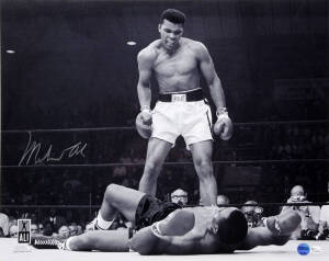 MUHAMMAD ALI, signed b/w photograph of Ali standing over Sonny Liston, size 51x41cm. With 'Online Authentics' No.OA-8090299.