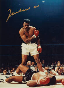 MUHAMMAD ALI, signed colour photograph of Ali standing over Sonny Liston, size 28x35cm. With CoA No.0452.