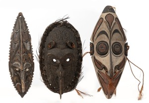 Three tribal masks, carved wood, shell and fibre with remains of painted finish, Papua New Guinea origin, the largest 53cm high