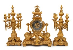 An impressive antique French three piece gilt metal clock set with candelabra garnitures, eight day time and strike movement and Roman numerals, 19th century, manufactured by LEMERLE CHARPENTIER, the clock 61cm high