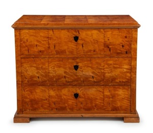 An antique Biedermeier chest of three drawers veneered in well selected Karelian satin birch with ebonized shield escutcheons, early 19th century, 93cm high, 112cm wide, 52cm deep