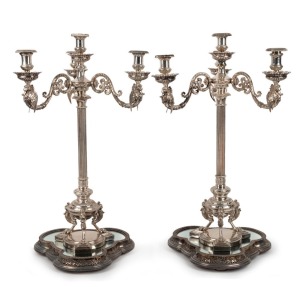 A stunning pair of Elkington antique English silver-plated candelabra with griffin decoration, together with mirrored silver-plated stands, also by Elkington, 19th century (four items). PROVENANCE: Ex Myers boardroom, Melbourne, 75cm high each overall