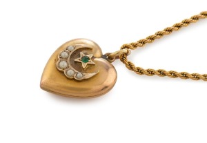 A yellow gold rope twist muff chain with an antique 9ct gold heart shaped pendant, set with seed pearls and emerald, 132cm long, 24 grams total