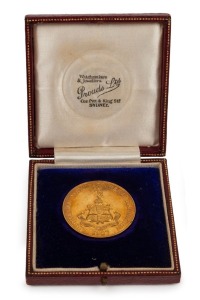 1927 AUSTRALIAN MANUFACTURER'S EXHIBITION gold medal (27.1gms) engraved on reverse "Awarded to COMMONWEALTH PORTLAND CEMENT CO LTD. KANDOS CEMENT CO LTD. SULPHIDE CORPORATION LTD." within a floral wreath; "9ct" engraved below. 38mm, housed in the original Prouds Ltd box in which it was presented to the Managing Director of Portland Cement.
