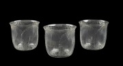 LALIQUE&nbsp;group of three French glasses with shell decoration and black enamel designs to the bases, engraved "R. LALIQUE, FRANCE", 5cm high