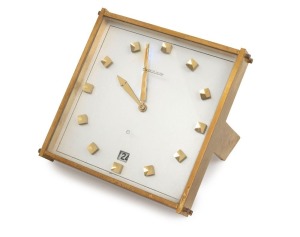 JAEGER LECOULTRE table clock in square form gilt brass case, eight day spring movement with lever escapement and date aperture with push button set, silvered dial, baton numerals, 20th century, 13cm high