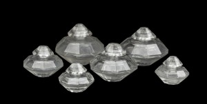Six assorted vintage French glass perfume bottles with faceted sides, in three sizes, 20th century, stamped "BOTTLE MADE IN FRANCE M.C.", the largest 5cm high, 57cm wide