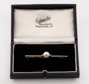 An 18ct white gold bar brooch, set with a cultured pearl flanked by a pair of brilliant cut white diamonds, mid 20th century, ​​​​​​​7.5cm wide, 3.9 grams - 2