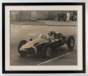 STERLING MOSS black and white action photograph, signed by the photographer lower right (illegible), ​​​​​​​39 x 49cm, 52 x 61cm overall