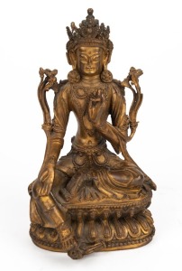 An antique Sino-Tibetan&nbsp;green Tara bronze figure seated on a double lotus base with lotus flowers at her side&nbsp;wearing a detailed incised dhoti, a pendant right leg resting on a lotus flower in full bloom, with a four-pronged lotus thunderbolt incised to t