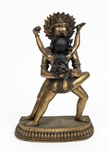 A Tibetan standing demonic figure embracing his consort, cast bronze with remains of gilt finish, standing on a semicircle lotus flower base, 20th century, ​​​​​​​39cm high