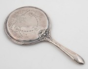 An antique silver hand mirror with engraved decoration, circa 1900, ​​​​​​​29cm high
