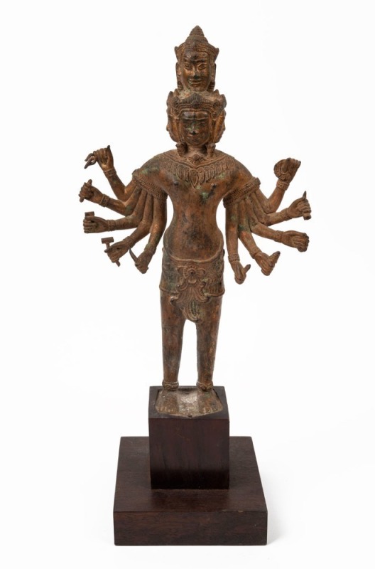 A cast bronze ten armed Buddhist statue with remains of gilt finish, 20th century, on later wooden stand, 36cm high, 48cm high overall