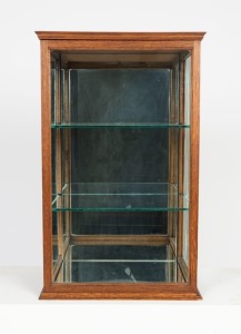 A solid English oak countertop display cabinet with moulded top, conforming base and two removable shelves, circa 1900, 65.5cm high, 41cm wide, 32cm deep