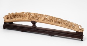 A Chinese carved ivory tusk on wooden stand, early to mid 20th century, ​​​​​​​51cm long