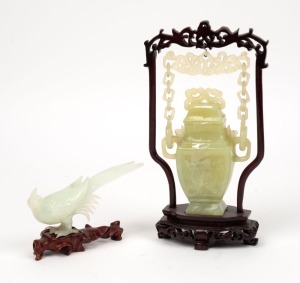 A Chinese carved jade bird ornament on wooden stand, together with a carved jade urn in suspended stand, 20th century, (2 items) the larger 23cm high overall