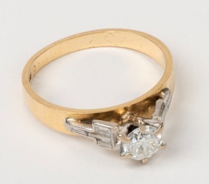 An 18ct yellow gold ring, set with a brilliant cut white diamond flanked by baguette diamonds mounted in white gold, stamped "18ct", 4.3 grams