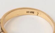 An 18ct yellow gold ring, set with a brilliant cut white diamond flanked by baguette diamonds mounted in white gold, stamped "18ct", ​​​​​​​4.3 grams - 2