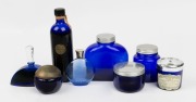 Eight assorted blue glass perfume and toiletry jars including WORTH, SOIR DE PARIS, GUERLAIN etc, the largest 17cm high