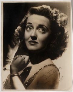 BETTE DAVIS signature and dedication in black ink on large format photograph by George Hurrell for Warner Brothers. 35.5 x 28cm overall. 