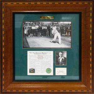 DON BRADMAN, display "Sir Donald Bradman A.C.", with signature on piece, window mounted with two photographs, limited edition 1003/2500, framed & glazed, overall 53x56cm. With CoA.