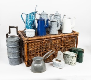 A basket of antique and vintage enamel wear, including tea pots, coffee jugs etc, (13 items), the basket 61cm wide.