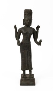 An antique Khmer cast bronze standing figure of the Hindu god Harihara, a combination of Vishnu and Shiwa, finely cast with detailed hair locks and realistic facial features, holding attributes in each hand, supported by a double square shaped pedestal ba