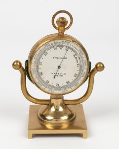 An antique pocket barometer in gilt metal case bearing broad arrow mark, with crown set altimeter scale and later stand, 19th century, 9.5cm high overall