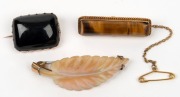 An antique 9ct&nbsp;gold mounted carved&nbsp;mother of pearl leaf brooch, a 9ct gold and tiger eye brooch, plus a 9ct gold and polished black stone brooch, 19th/20th century, (3 items), ​​​​​​​the largest 5cm wide