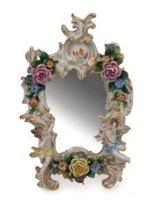 An antique German porcelain table mirror with applied cherubs and flowers, 19th century, 31cm high