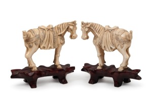 A pair of antique Chinese carved ivory warhorse statues on carved wooden bases, 19th/20th century, 8cm high