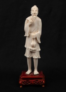 A Chinese carved ivory statue of an old man, mounted on a carved wooden base, Republic period, 20th century, ​​​​​​​18cm high overall