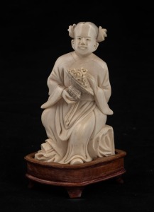 A Chinese carved ivory statue of a seated figure with flowers, on carved wooden stand, Republic period, 20th century, ​​​​​​​12.5cm high overall