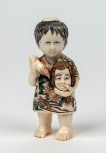 A Japanese carved ivory and hand-painted statue of a child with a mask, Meiji Period, 20th century, signature to base, ​​​​​​​8cm high