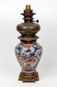 An antique oil lamp with Imari porcelain base, gilt metal mounts and fonts, (electrified and cord cut), 19th century, 55cm high