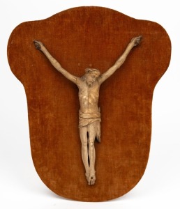 An antique carved ivory crucifix, mounted on later velvet covered board, 19th century or earlier, the crucifix 25cm high, 34cm high overall&nbsp;