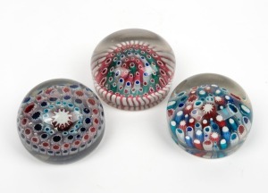 Three antique glass paperweights with candy cane and millefiori decoration, French and English, the largest 6cm high, 9.5cm wide