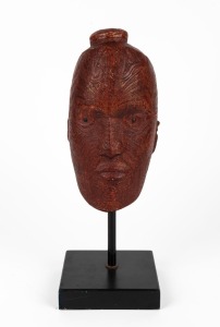 A hand-painted fired plaster Maori head on stand, 20th century, ​​​​​​​40cm high overall