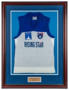 ex NATHAN BUCKLEY COLLECTION:&nbsp;Commemorative &lsquo;Rising Star&rsquo; guernsey awarded to Nathan Buckley for winning the Norwich Rising Star award in 1993. Blue and white jumper with AFL and Norwich logos. Framed & glazed. This was the inaugural year of the Rising St