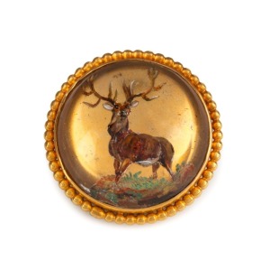 An antique 15ct gold mounted Essex crystal circular brooch with stag decoration, 19th century, stamped "15ct", 2.5cm diameter, 11.4 grams total